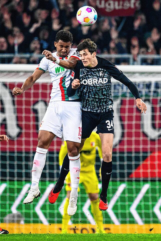 Augsburgs Felix Uduokhai (l) in Aktion gegen Freiburgs Merlin Röhl (r).