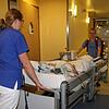 Jetzt schieben sie den Intensivpatienten in den Lift des Altbaus und von dort zum Steg in den Neubau.