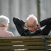 Senioren sitzen auf einer Bank. Als Pensionäre sind sie in der Regel besser gestellt als Rentner. Sie kosten aber auch eine Menge Geld.