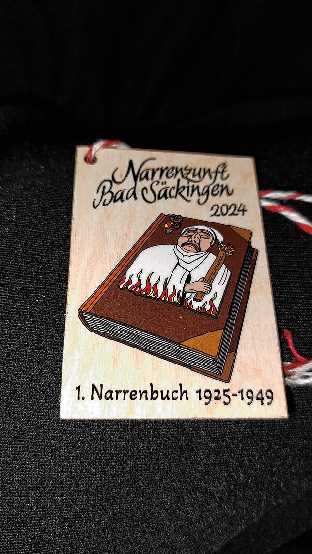 Die diesjährige Fasnachtsplakette erinnert an die Narrenbücher der Zunft.