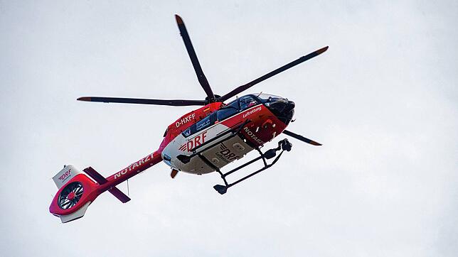 (Symbolbild) – Ein Motorradfahrer prallt bei einem Überholvorgang mit einem entgegenkommenden Fahrzeug zusammen. Er wird schwer verletzt ...