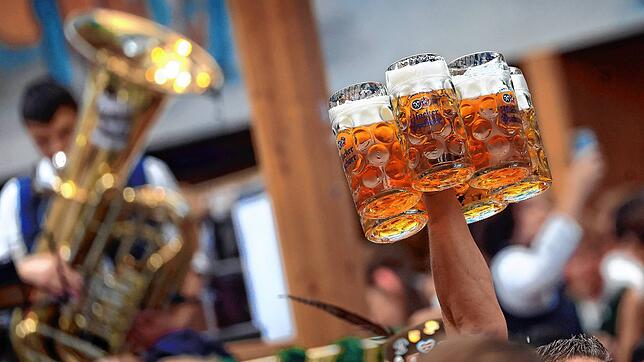 Eine Bedienung trägt im Hacker-Pschorr-Festzelt auf dem Oktoberfest mehrere Maßkrüge. (Archivbild 2024)