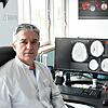 Der Singener Neurochirurg Aram Bani in seinem Büro. Auf dem Bildschirm sind anonymisierte Computertomografie-Aufnahmen eines verletzten ...
