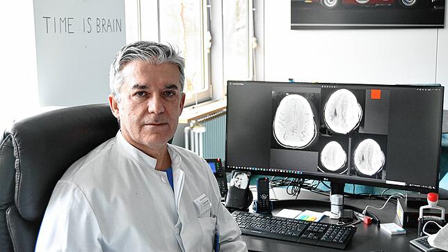 Der Singener Neurochirurg Aram Bani in seinem Büro. Auf dem Bildschirm sind anonymisierte Computertomografie-Aufnahmen eines verletzten ...