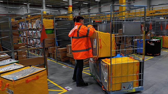 Die Pakete sind in den Taschen verstaut. Eine Amazon-Mitarbeiterin stellt auf dem Packwagen die Pakete für eine Tour zusammen.