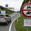 Ein Auto wird von einem Beamten angehalten bei einer Autobahnauffahrt. In Tirol hat die Polizei auch am Sonntag die neuen Fahrverbote ...