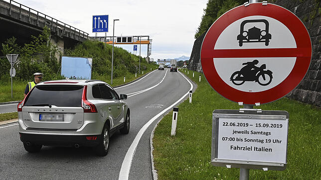 Ein Auto wird von einem Beamten angehalten bei einer Autobahnauffahrt. In Tirol hat die Polizei auch am Sonntag die neuen Fahrverbote ...