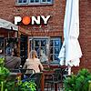 24.05.2024, Schleswig-Holstein, Kampen: Zwei Frauen sitzen auf der Terrasse des Club ·Pony· in Kampen (Sylt). Hier hatten Party-Gäste zu ...