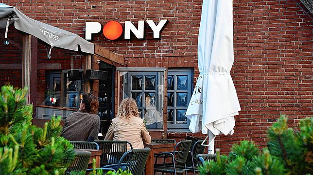 24.05.2024, Schleswig-Holstein, Kampen: Zwei Frauen sitzen auf der Terrasse des Club ·Pony· in Kampen (Sylt). Hier hatten Party-Gäste zu ...