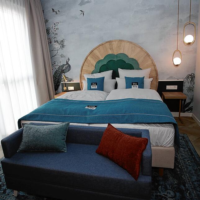 Ein Pfau schaut zum Bett: So sieht es in einem der 190 Hotel-Zimmern aus.