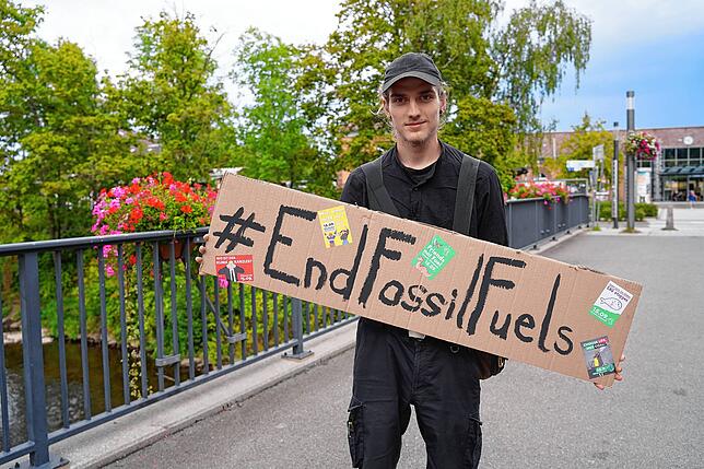 Jonathan Kühner von Fridays for Future Villingen-Schwenningen zeigt auf dem Plakat das Motto des globalen Streiktags: „Schluss mit ...