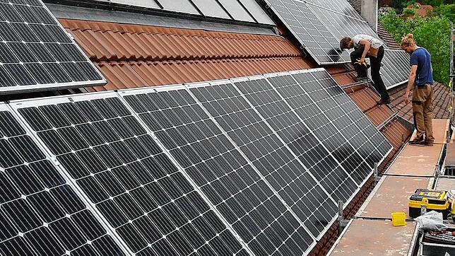 Zwei Installateure montieren Solarpanels für eine Photovoltaik-Anlage auf dem Hausdach einer Markdorfer Familie (Archivbild).