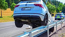 Das Auto bleibt auf der Leitplanke stehen.