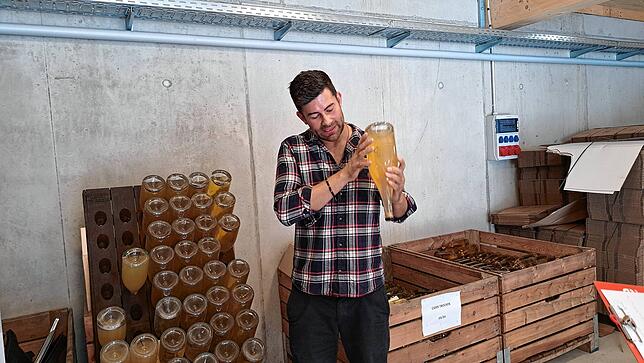 Bruno Stotz hält eine Flasche des hauseigenen Cider und erklärt den Juroren des Ceres Award von der Produktion.