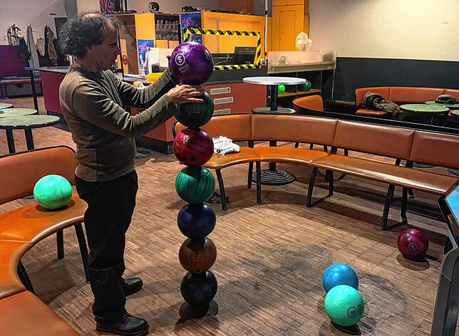 Hoch konzentriert stapelt Volker Paul über fünf Stunden Bowlingkugeln aufeinander.