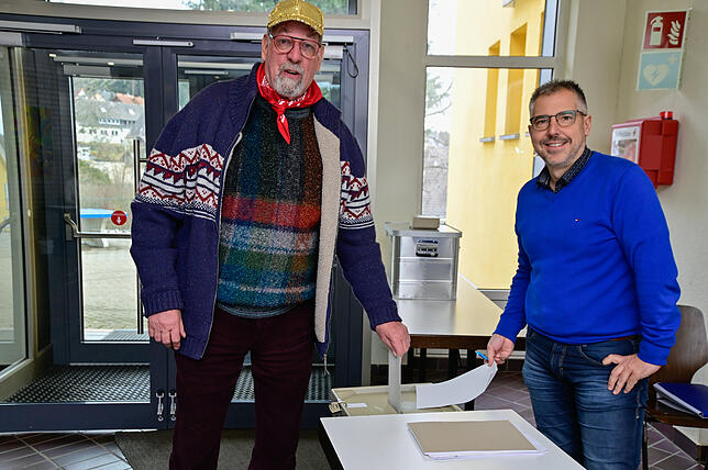 Oskar Beha (links, mit Wahlhelfer Michael Staiger) wirft seinen Stimmzettel in die Urne im Wahllokal in Peterzell.