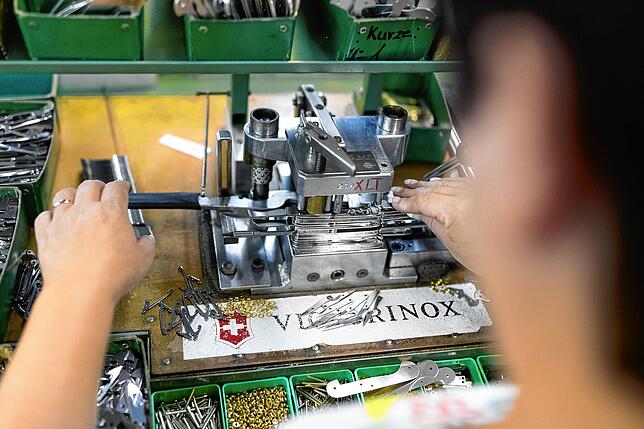 Ein Mitarbeiter montiert im Victorinox-Werk ein Taschenmesser.