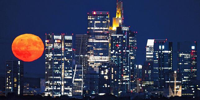 Der riesig wirkende Erdbeermond am 11. Juni über der Bankenskyline von Frankfurt. Der Erdtrabant wirke kurz nach dem Aufgehen generell ...