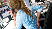 Wer im Job viel sitzt, sollte regelmäßig kleine Bewegungspausen einbauen. Das beugt Rückenschmerzen vor.