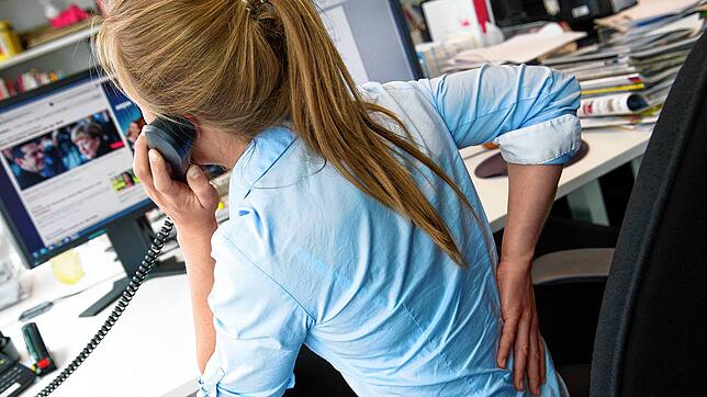 Wer im Job viel sitzt, sollte regelmäßig kleine Bewegungspausen einbauen. Das beugt Rückenschmerzen vor.