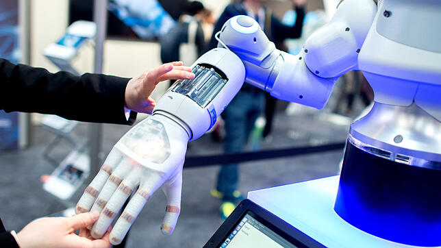 Eine Frau hält am Stand von Festo auf der Hannover Messe die Hand eines bionischen Roboters. Was sich heute noch nach Zukunftsmusik ...