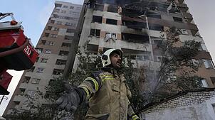 Ein Feuerwehrmann ist nach israelischen Angriffen am Ort einer Explosion in einer Wohnanlage in Teheran  im Einsatz.