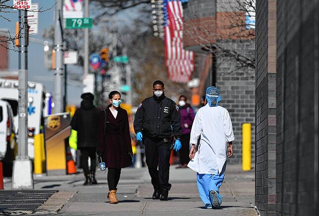Mit Mundschutz gehen Menschen im New Yorker Stadtteil Queens ins Freie. Die Angst, sich mit dem Virus zu infizieren, ist bei vielen ...