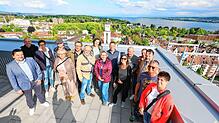 Ganz weit oben! Acht Abonnenten und ihre Begleitungen stehen bei „Der SÜDKURIER öffnet Türen“ auf der Dachterrasse der Ode Lofts im ...
