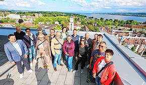 Ganz weit oben! Acht Abonnenten und ihre Begleitungen stehen bei „Der SÜDKURIER öffnet Türen“ auf der Dachterrasse der Ode Lofts im ...