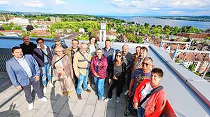 Ganz weit oben! Acht Abonnenten und ihre Begleitungen stehen bei „Der SÜDKURIER öffnet Türen“ auf der Dachterrasse der Ode Lofts im ...