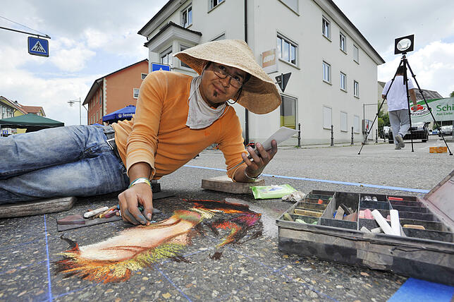Der erfahrene Street-Art-Maler weiß: Ein Strohhut schützt vor zu viel Sonne.