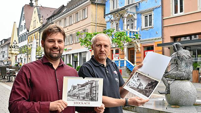 Julian Windmöller, Leiter des Stadtarchivs und -museums, sowie Michael Fritz von Papier Fritz stehen in der Hauptstraße und Windmöller ...
