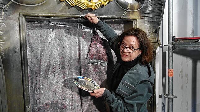 Restauratorin Caroline Walther mischt in der St.-Martins-Kirche den passenden Farbton auf einem Teller zusammen. Mit feinen Pinseln ...