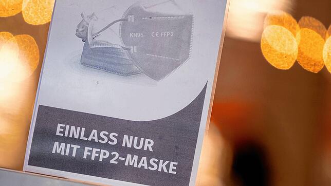 Ein Schild auf der Eingangstür eines Einzelhandelsgeschäfts weist auf unserem Symbolbild auf das Tragen einer FFP2-Maske hin.