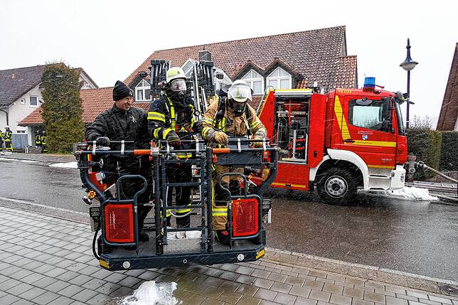Kaminfeger Andreas Saier (links) wird mit der Drehleiter hoch zum Brandort geschwenkt.