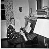 Thomas Neumann im Jahr 1967 am Klavier im Wohnzimmer der Dienstwohnung seines Vaters Dr.&nbsp;Paul Naumann, evangelischer Pfarrer der ...