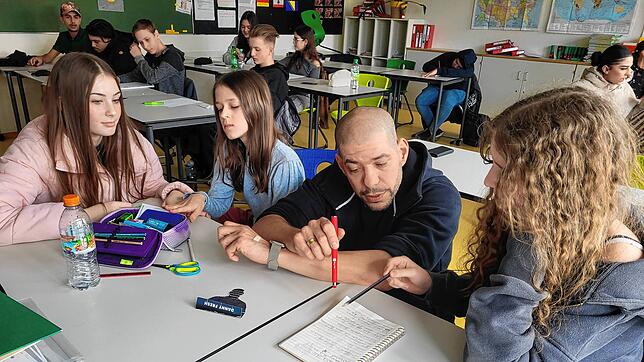 Rapper Danny Fresh hilft den Schülerinnen Alda, Mila und Julia der achten Klasse dabei, einen gemeinsamen Songtext zu schreiben.