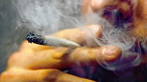 Ein Mann raucht einen Joint (Symbolbild). Ein Autofahrer wurde in Waldshut an der Grenze gestoppt. Er hatte Marihuana dabei und war von ...