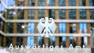 Der Bundesadler und der Schriftzug “Auswärtiges Amt„ sind an einer Glasscheibe an einem Eingang zum Auswärtigen Amt zu sehen.