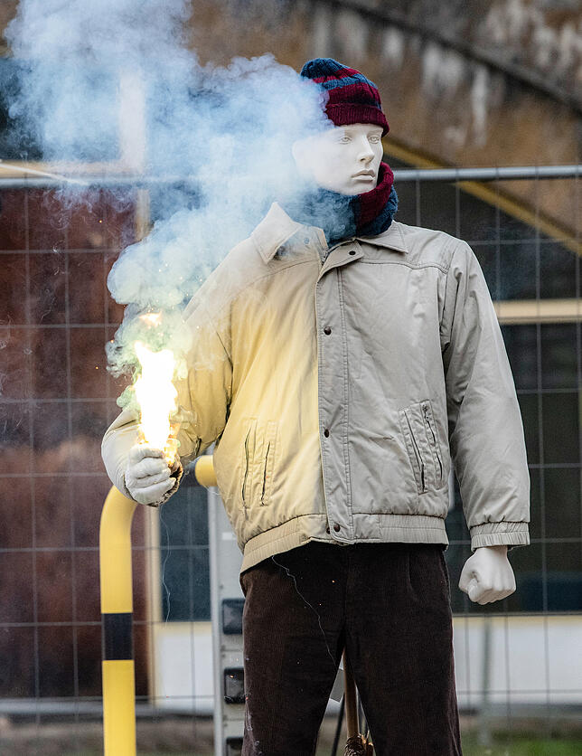 In der Hand eines Dummys der Feuerwehr brennt ein illegaler Böller.