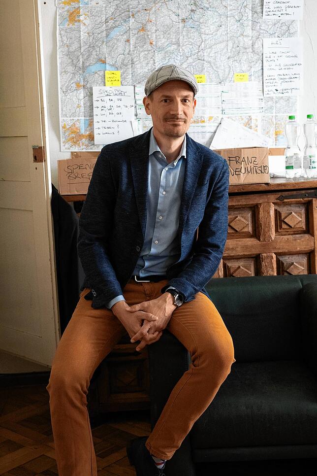 Michael Bubendorfer sitzt in einem Büro der Verfassungsfreunde vor einer Karte mit den Ortsvereinen.