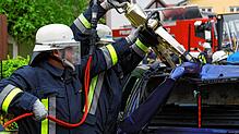 Feuerwehrleute schneiden ein Auto auf. (Symbolbild) Auf diese Weise mussten Einsatzkräfte einen Fahrer nach einem Unfall bei Schwörstadt ...