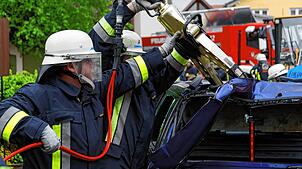 Feuerwehrleute schneiden ein Auto auf. (Symbolbild) Auf diese Weise mussten Einsatzkräfte einen Fahrer nach einem Unfall bei Schwörstadt ...