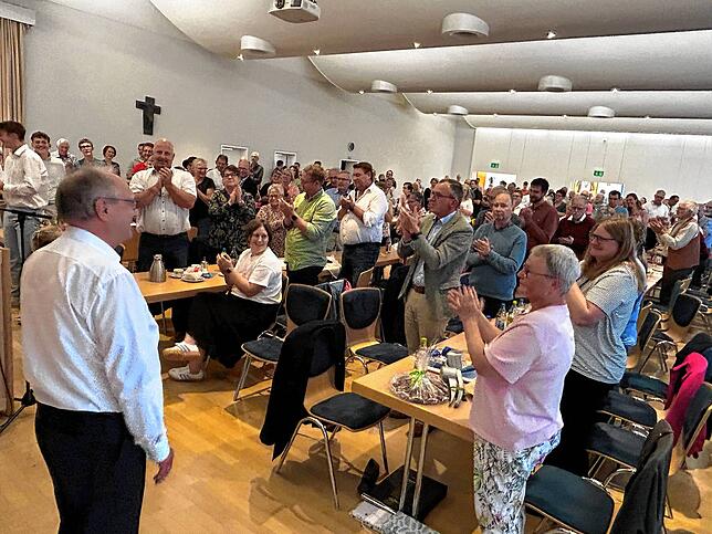 Respekt vor der Lebensleistung: Die Besucher erheben sich zum Dank an Josef Fischer für sein Wirken als Pfarrer, Dekan und Seelsorger.