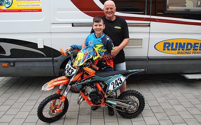 Leon Vötsch mit seinem Opa Helmut Kosmowski vor ihrem Motocross-Wohnmobil. Das Opa-Enkel Gespann reist damit von Wettkampf zu Wettkampf.