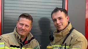 Nach der geglückten Rettungsaktion halten die beiden Einsatzkräfte Robert Hofberger (l) und Philipp Romer das Tier in den Händen.