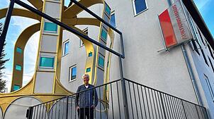 Reiner Schorer posiert fürs Foto mit der riesigen Krone, die nun in der Schwenninger Marktstraße ihren Platz gefunden hat – zumindest ...