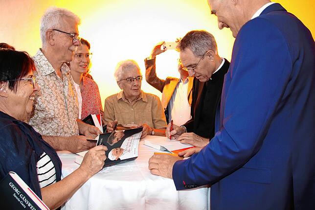 Gänswein (Zweiter von rechts) signiert sein Buch, rechts: Verleger Manuel Herder.