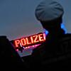 Zwei Polizisten stehen vor einem Polizeifahrzeug (Symbolbild). In Lörrach sucht die Polizei nach einem Mann, der sich vor drei Mädchen ...
