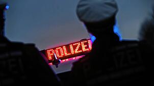 Zwei Polizisten stehen vor einem Polizeifahrzeug (Symbolbild). In Lörrach sucht die Polizei nach einem Mann, der sich vor drei Mädchen ...